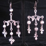 These earrings come from the town of Yalalag in the state of Oaxaca, Mexico. This design dates from colonial times when the Spanish ruled Mexico. The symbolism of the Yalalag cross refers to the crucifixion with the large cross representing Jesus and the three smaller crosses for the three men sentenced to death on the mountain with Jesus.